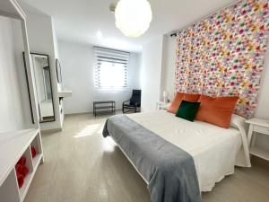 a bedroom with a large bed with a colorful wall at LHOME CÁDIZ in Cádiz