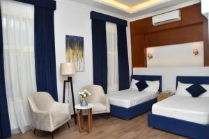 a hotel room with two beds and a chair at Loaloat maadi Hostel "Cornich Elnile" in Cairo