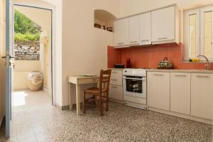 a kitchen with white cabinets and a table with a chair at Theros Home Andros in Andros