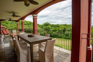 patio con mesa de madera y sillas en el balcón en Bougainvillea 8211 Luxury Apartment - Reserva Conchal, en Playa Conchal