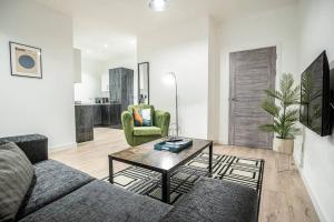 a living room with a couch and a table at Bayard Apartments City Centre 2 Bedroom Apartment in Peterborough