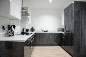 a kitchen with wooden cabinets and a white counter top at Bayard Apartments City Centre 2 Bedroom Apartment in Peterborough