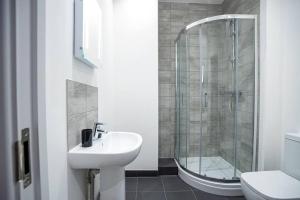 a bathroom with a shower and a sink and a toilet at Bayard Apartments City Centre 2 Bedroom Apartment in Peterborough