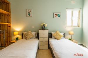 dos camas sentadas una al lado de la otra en un dormitorio en Penthouse with Stunning City Views, en Xewkija