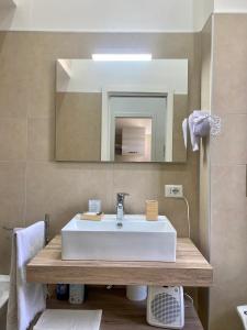 uma casa de banho com um lavatório branco e um espelho. em Casa Panorama, casa vacanza. em Torre del Greco