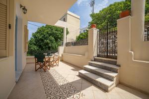 a patio with stairs and a table and chairs at Theros Home Andros in Andros