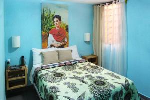 1 dormitorio con 1 cama con una pintura en la pared en Colorida Casa Azul en Texcoco Centro WiFi Cocina, en Texcoco de Mora