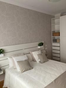una camera da letto con un grande letto bianco con due cuscini di Bonbillo - ONGI ETORRI a Zumaia