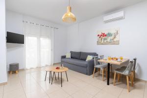 uma sala de estar com um sofá e uma mesa em Sun Beach Apartments em Kato Daratso