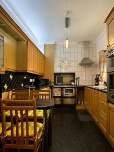 SwordaleDairy Cottage的配有木制橱柜、桌子和椅子的厨房