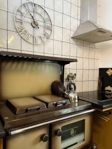 een keuken met een klok aan de muur bij Dairy Cottage in Swordale