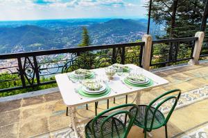 a table with plates and wine glasses on a balcony at Villa I Tigli - by MyHomeInComo in Brunate