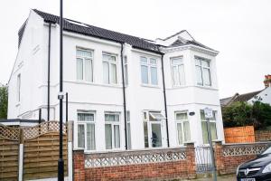 a white house with a brick fence at Centra Studios in London