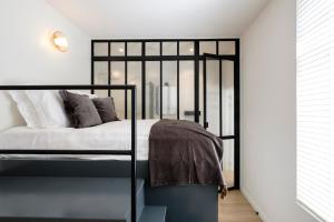 1 dormitorio con cama negra y ventana en The Rose Flats en Bruselas