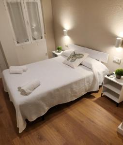 a bedroom with a large white bed with two towels on it at Hostal Restaurante CASA FRAN in La Pueblanueva