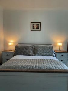 a bedroom with a large bed with two lamps on tables at Dairy Cottage in Swordale