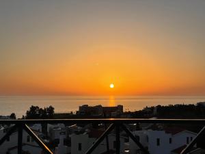 um pôr-do-sol a partir da varanda de um edifício em Ocean Wings Panoramic SeaView em Kissonerga