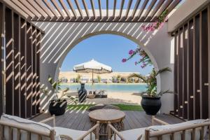 an outdoor patio with an archway and a table and chairs at Le Sidi - A TLT Signature Hotel in El Alamein