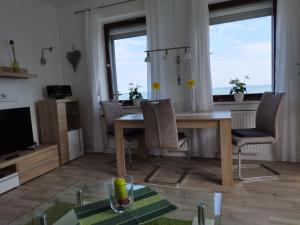 ein Wohnzimmer mit einem Holztisch und Stühlen in der Unterkunft Ferienwohnung mit Meerblick in Dahme