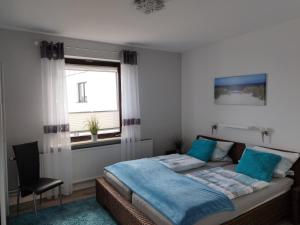 ein Schlafzimmer mit einem Bett, einem Stuhl und einem Fenster in der Unterkunft Ferienwohnung mit Meerblick in Dahme