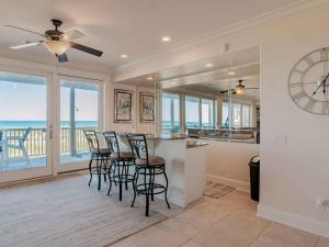 een keuken met barkrukken en uitzicht op de oceaan bij Coastal Haven by Southern Vacation Rentals in Pensacola Beach