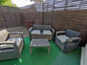 patio z 3 krzesłami oraz stołem i krzesłami w obiekcie La Villa Beata w Orange