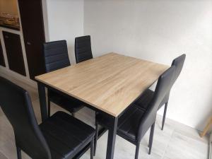 een houten tafel met vier stoelen in een kamer bij La Villa Beata in Orange