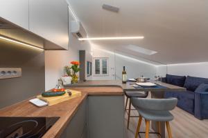 a kitchen and living room with a blue couch at Apartment Ena Arena Pula in Pula