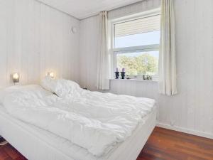 een wit bed in een kamer met een raam bij Holiday home Aabenraa LXXII in Aabenraa