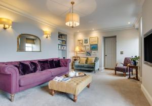 a living room with a purple couch and a table at Orchard Cottage in Newlyn