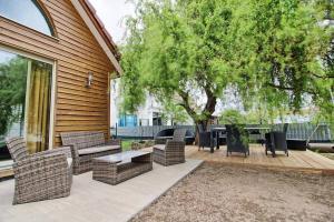 eine Terrasse mit Stühlen, Tischen und einem Baum in der Unterkunft Maison Le Vignoble avec jardin - 6 personnes in Ribeauvillé