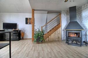 uma sala de estar com uma escada e uma lareira em Maison Le Vignoble avec jardin - 6 personnes em Ribeauvillé