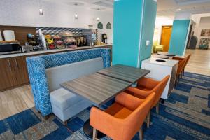 a dining room with a table and orange chairs at Wingate by Wyndham Lafayette Airport in Lafayette