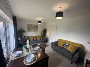 a living room with two couches and a table at 3 Bed Home for Contractors & Relocators with Parking, Garden & WiFi 5 mins walk to Town Centre & Train Station in Stafford