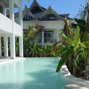 a swimming pool in front of a house at Kobe House in Jambiani