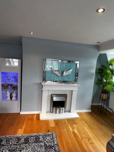 a living room with a fireplace with a tv on the wall at One bedroom flat in Chelsea in London