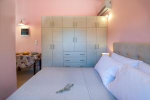 a bedroom with a bed with white cabinets and a desk at Kabos house in Mastorátika