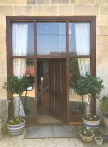 a glass door with two potted plants in front of it at Converted Coach House Holt, Wiltshire in Holt