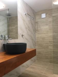 パレオ・ティフリキにあるSecret Bayのバスルーム(黒い洗面台、シャワー付)