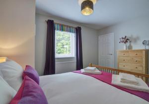 um quarto com uma cama grande e uma janela em Puffins Retreat em Braunton