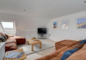 a living room with two couches and a tv at Pixie Croft in Braunton