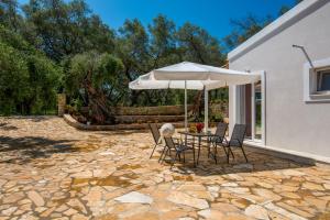 a patio with a table and an umbrella at Kabos house in Mastorátika