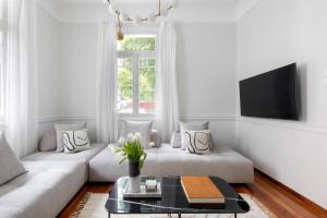 アテネにあるAcropolis Villa 3BR 9ppl 10 minutes Metro&Museumのソファとテレビのある白いリビングルーム