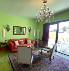 a living room with a red couch and a chandelier at Basarte Cottage in Bakio