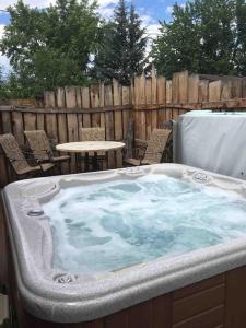eine Whirlpool-Badewanne im Hinterhof mit Tisch und Stühlen in der Unterkunft Beautiful Perfectly Located Hot Tub Fire Pit Bikes in Colorado Springs