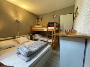 a bedroom with a bed and a counter and bunk beds at Appart 2 Étoiles 6-8 pers Piau Engaly L Ours Résidence Moudang II Pied pistes in Aragnouet