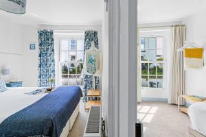 um quarto com uma cama grande e 2 janelas em Bay Cottage, Brixham em Brixham