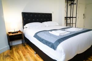 a bedroom with a large bed with a black headboard at Centra Studios in London