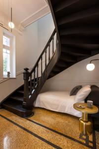 アテネにあるAcropolis Villa 3BR 9ppl 10 minutes Metro&Museumの階段のある部屋(ベッド1台、テーブル付)