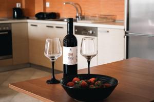 a bottle of wine and two wine glasses on a table at Home Sweet Home Unique Sea View in Sivota